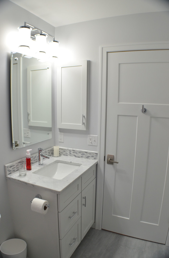 Transitional gray tile bathroom photo with shaker cabinets, white cabinets and marble countertops