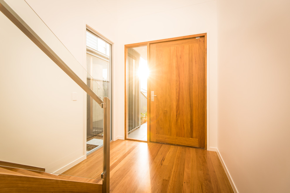 Small contemporary front door in Brisbane with white walls, medium hardwood floors, a pivot front door and a medium wood front door.