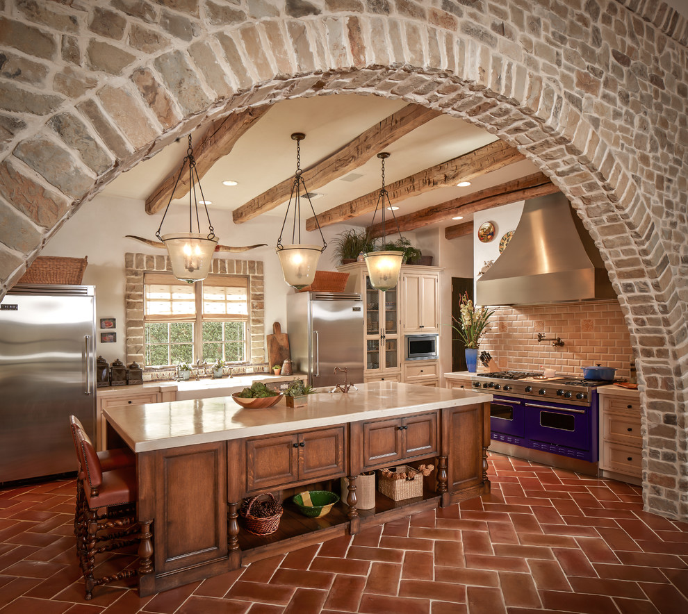 Inspiration for a mediterranean kitchen in Houston with coloured appliances, terra-cotta floors and beige benchtop.