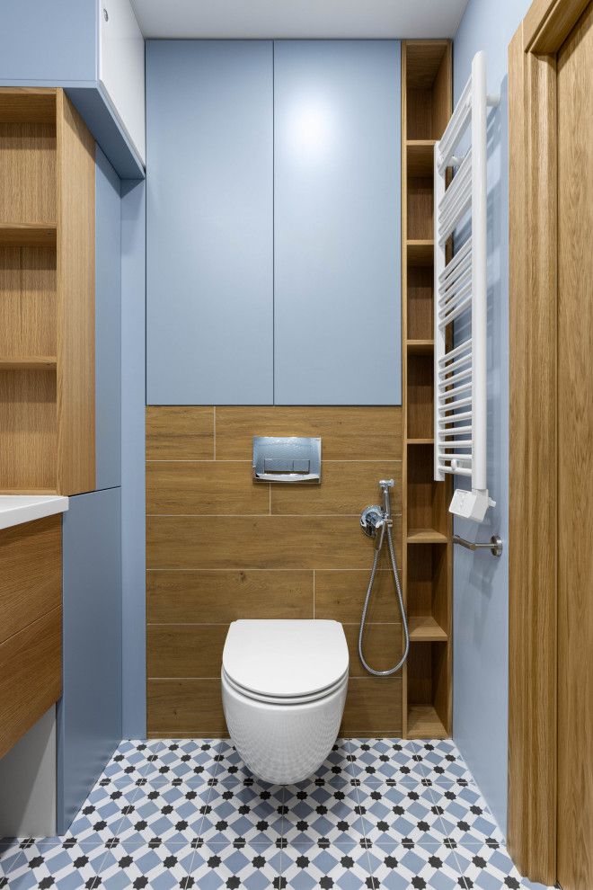 Idee per un bagno di servizio nordico di medie dimensioni con ante lisce, ante blu, piastrelle blu, top in superficie solida, top bianco e mobile bagno sospeso