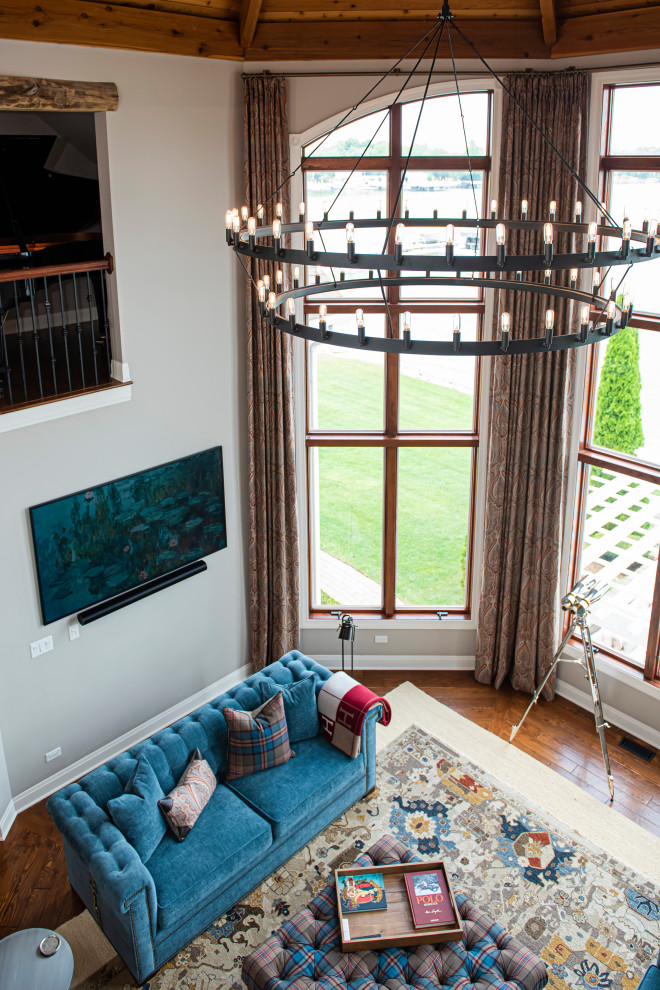 Foto di un soggiorno boho chic di medie dimensioni e chiuso con pareti grigie, pavimento in legno massello medio, TV a parete, soffitto a volta e pavimento marrone
