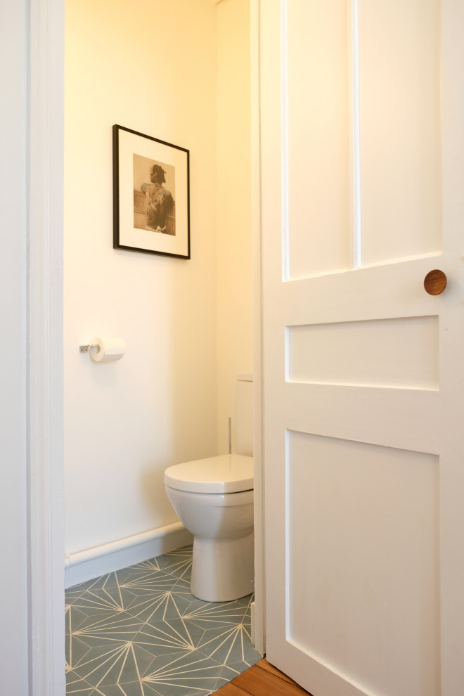 Cette photo montre un petit WC et toilettes rétro avec WC à poser, un carrelage blanc, des carreaux de béton, carreaux de ciment au sol et un sol vert.