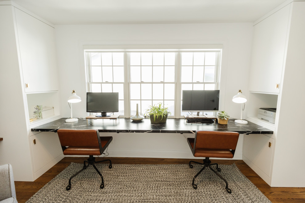 На фото: кабинет в стиле фьюжн с белыми стенами, паркетным полом среднего тона и встроенным рабочим столом с