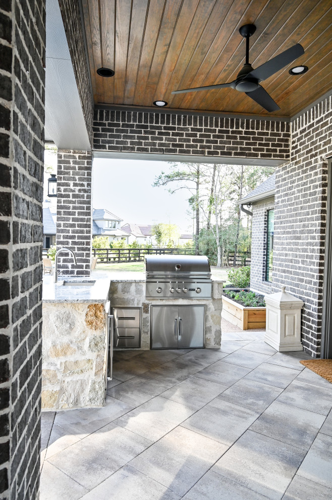 Immagine di un patio o portico dietro casa con piastrelle e un tetto a sbalzo