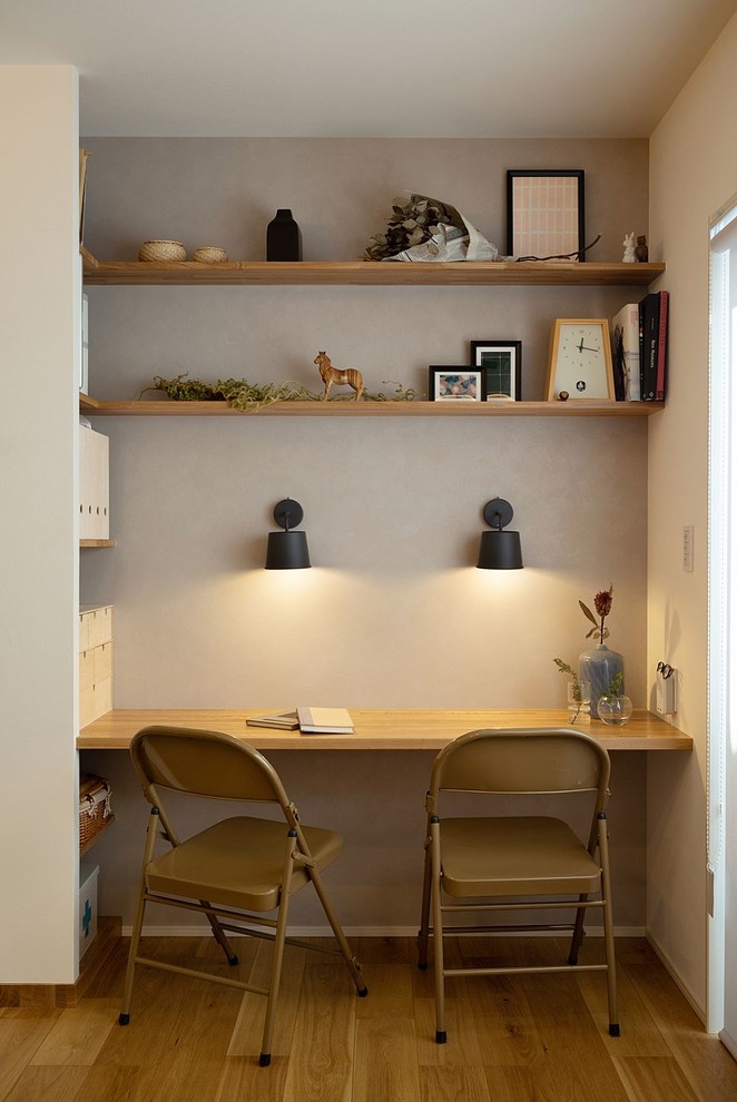 Small scandinavian home office in Nagoya with grey walls, medium hardwood floors, a built-in desk and brown floor.