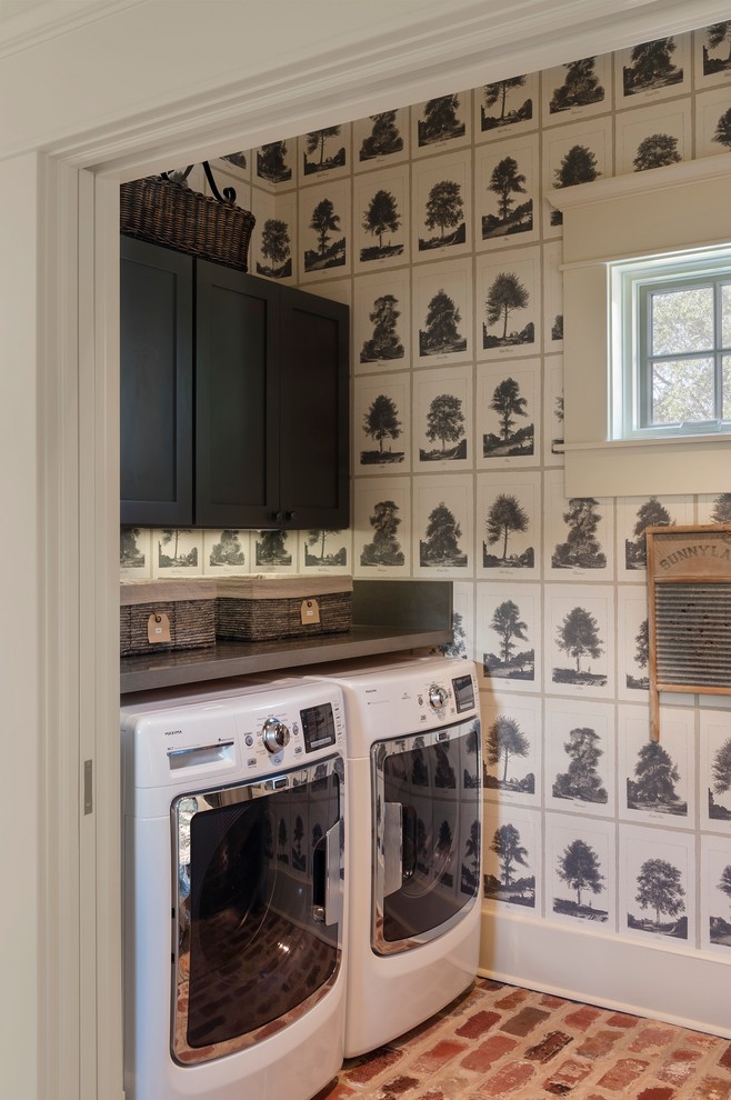 Country laundry room in Houston with shaker cabinets, black cabinets, multi-coloured walls, brick floors, a side-by-side washer and dryer and grey benchtop.