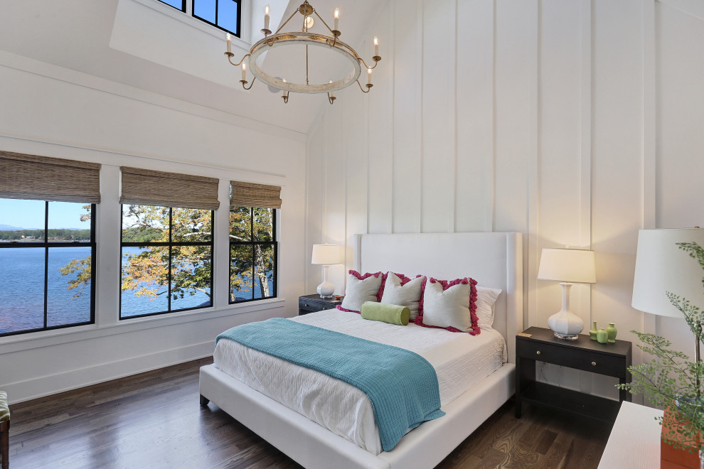 Photo of a large transitional master bedroom in Other with white walls, medium hardwood floors, brown floor, vaulted and panelled walls.