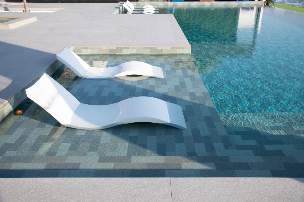 Стильный дизайн: ландшафтный бассейн среднего размера, произвольной формы на заднем дворе в морском стиле с покрытием из плитки - последний тренд
