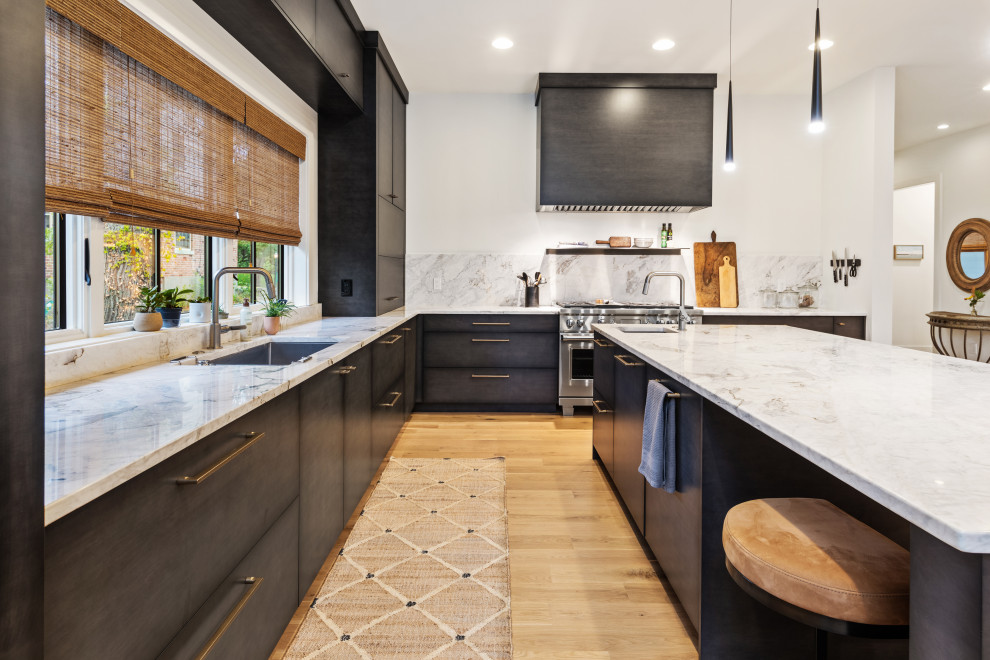 This is an example of a mid-sized modern l-shaped open plan kitchen in Cincinnati with an undermount sink, flat-panel cabinets, grey cabinets, marble benchtops, white splashback, marble splashback, stainless steel appliances, light hardwood floors, with island, beige floor and white benchtop.