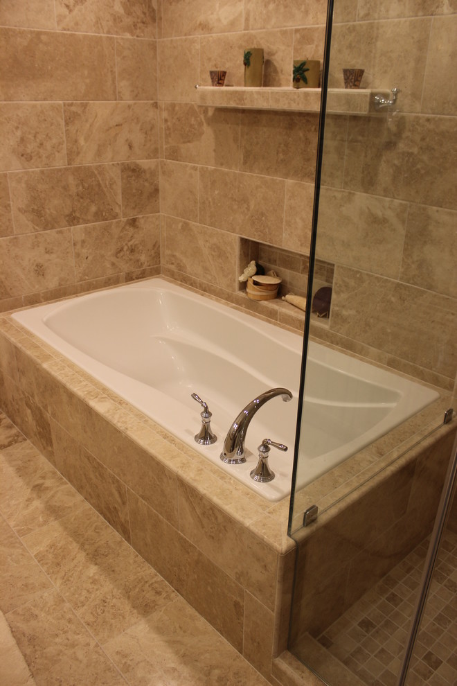 Photo of a large mediterranean master bathroom in DC Metro with an undermount sink, raised-panel cabinets, beige cabinets, granite benchtops, a corner shower, a two-piece toilet, brown tile, stone tile, brown walls, travertine floors and a drop-in tub.
