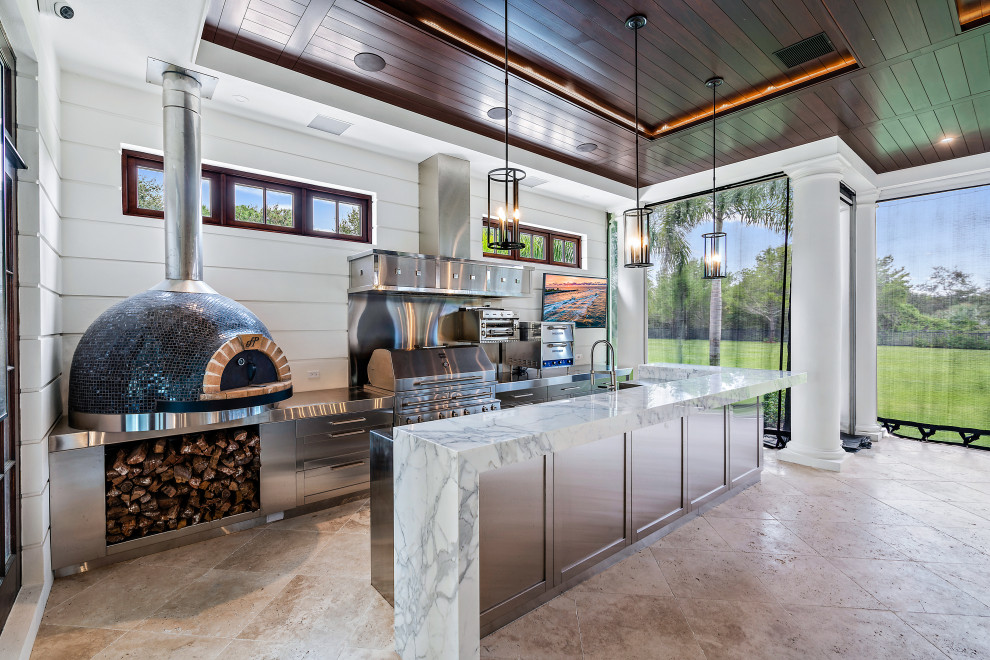 This is an example of a large transitional backyard patio in Miami with an outdoor kitchen, tile and a roof extension.