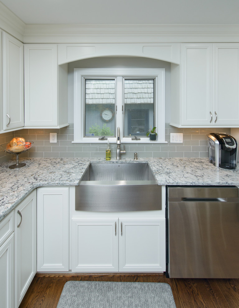 Kitchen - large transitional l-shaped dark wood floor and brown floor kitchen idea in Baltimore with a farmhouse sink, recessed-panel cabinets, white cabinets, quartz countertops, gray backsplash, subway tile backsplash, stainless steel appliances and an island