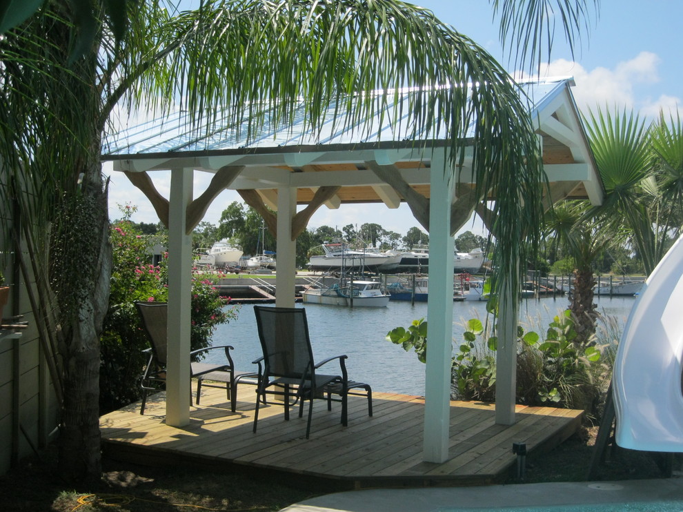 Inspiration for a small tropical backyard patio in Tampa with a gazebo/cabana and decking.