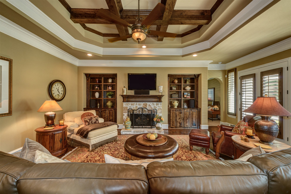 Inspiration for a large traditional open concept family room in Dallas with brown walls, medium hardwood floors, a standard fireplace, a stone fireplace surround, a wall-mounted tv and brown floor.