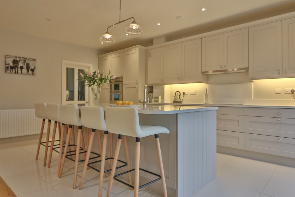 This is an example of a mid-sized modern single-wall open plan kitchen in Dublin with shaker cabinets, with island and vaulted.
