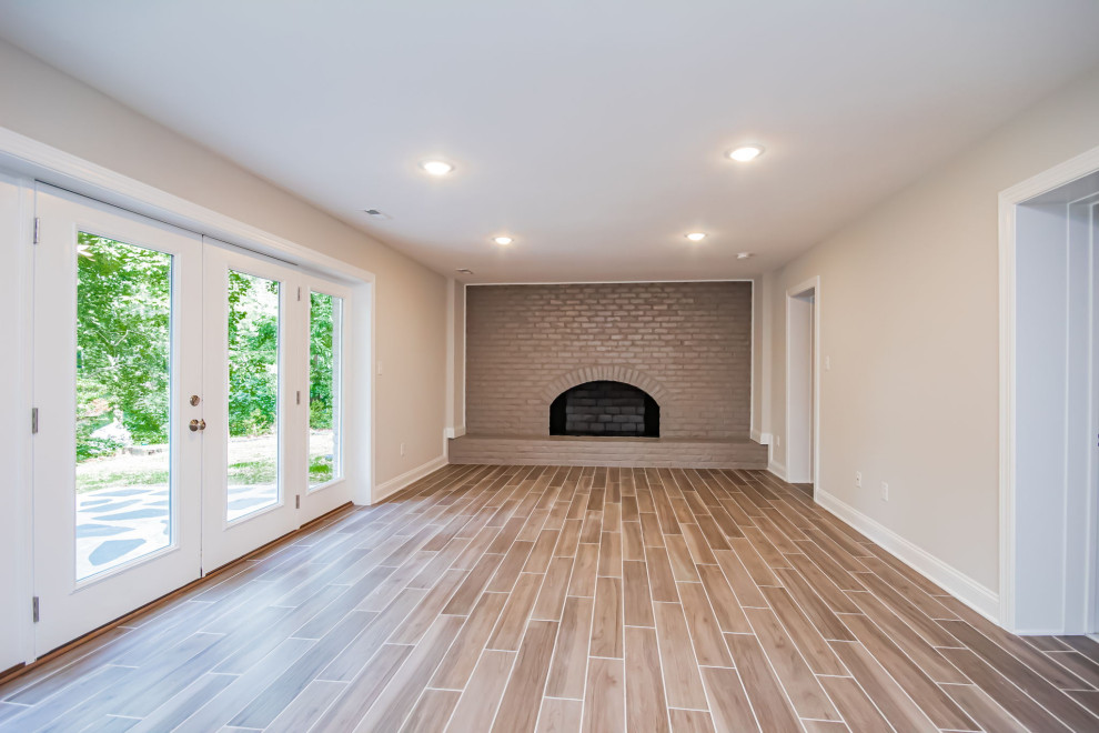 リッチモンドにある高級な中くらいなトラディショナルスタイルのおしゃれな独立型ファミリールーム (ゲームルーム、グレーの壁、セラミックタイルの床、標準型暖炉、レンガの暖炉まわり、茶色い床) の写真