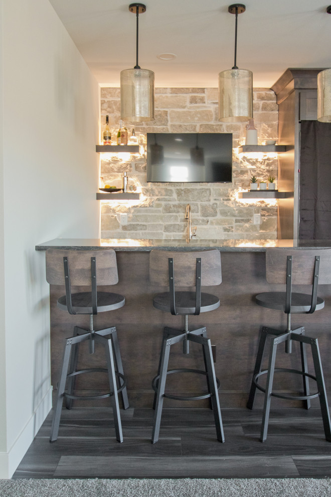 Inspiration for a small transitional single-wall home bar in Other with recessed-panel cabinets, medium wood cabinets, beige splashback, brick splashback, vinyl floors, grey floor, black benchtop and quartz benchtops.