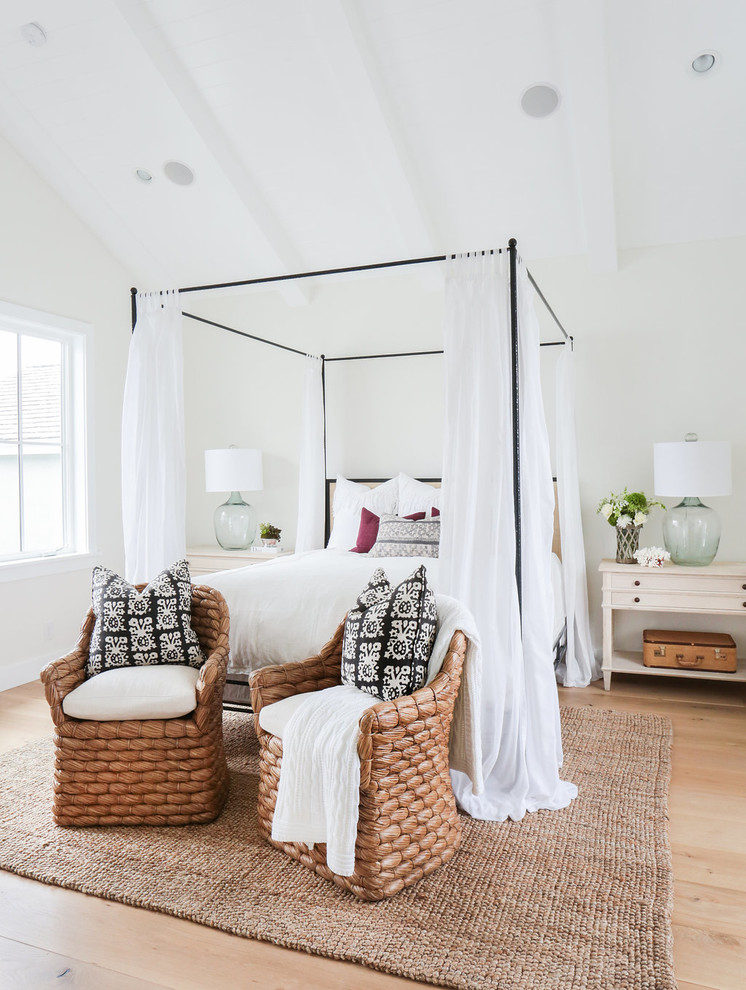 Design ideas for a country master bedroom in Orange County with white walls and light hardwood floors.