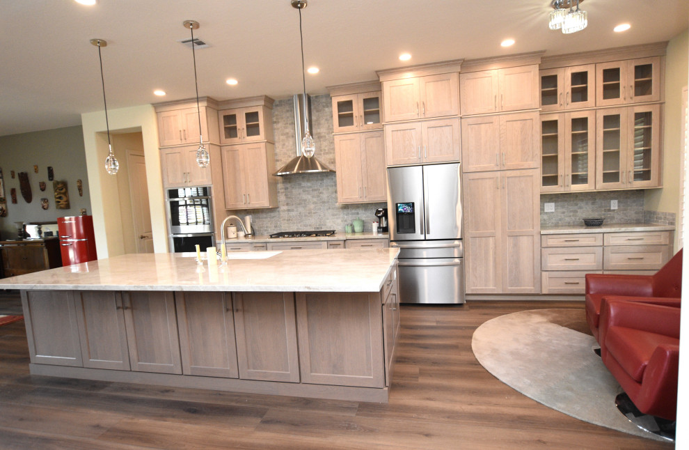 Large transitional vinyl floor kitchen photo with an undermount sink, shaker cabinets, light wood cabinets, quartzite countertops, multicolored backsplash, porcelain backsplash, stainless steel appliances, an island and beige countertops