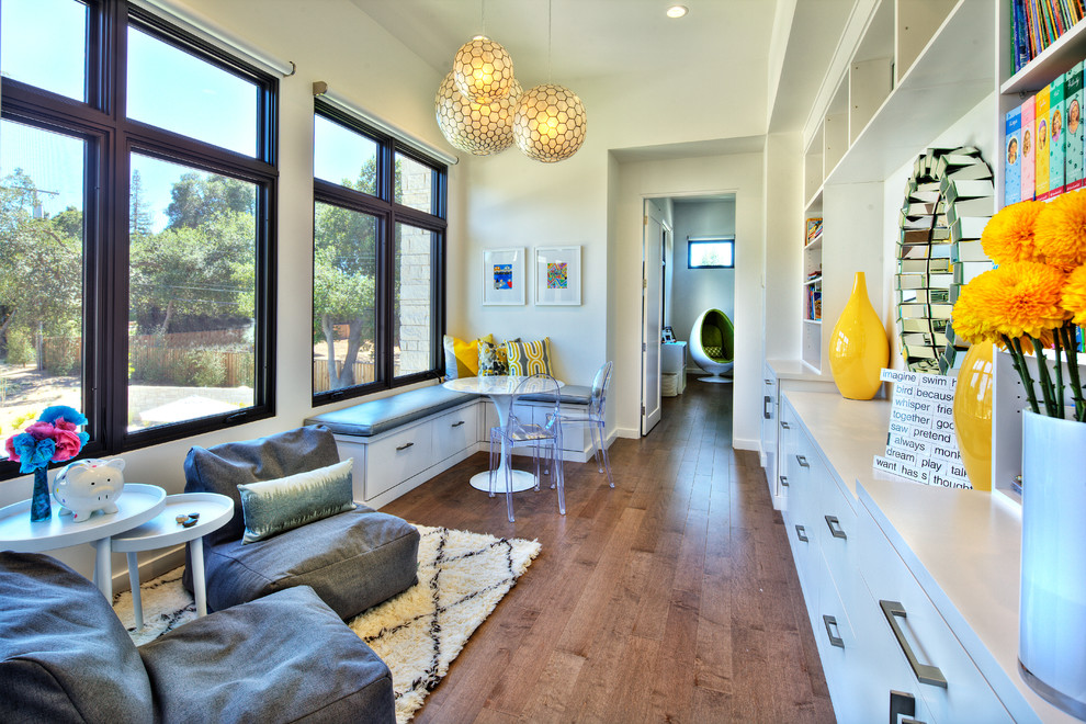 Photo of a large contemporary kids' room for girls in Sacramento with white walls, medium hardwood floors and brown floor.