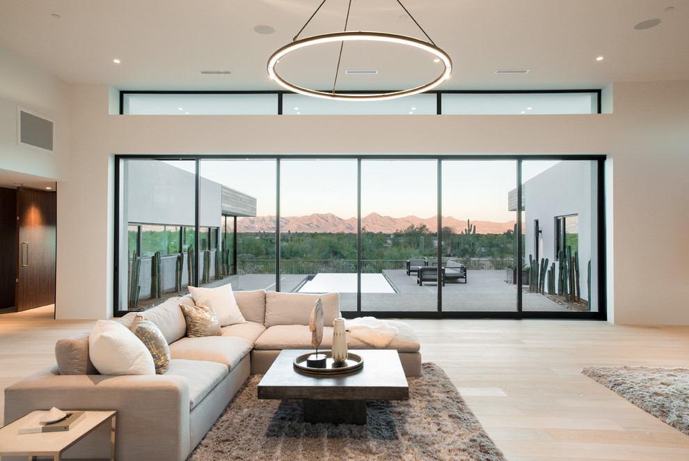 Inspiration for a large modern open concept living room in Phoenix with white walls, light hardwood floors, a two-sided fireplace and a concrete fireplace surround.