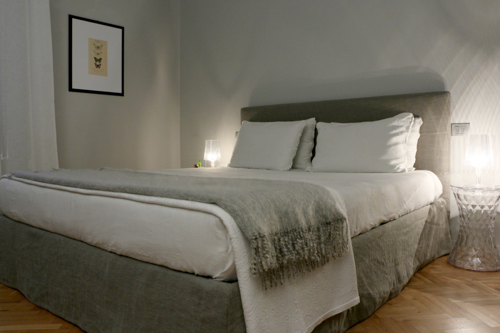 他の地域にある中くらいなコンテンポラリースタイルのおしゃれな主寝室 (グレーの壁、淡色無垢フローリング) のレイアウト