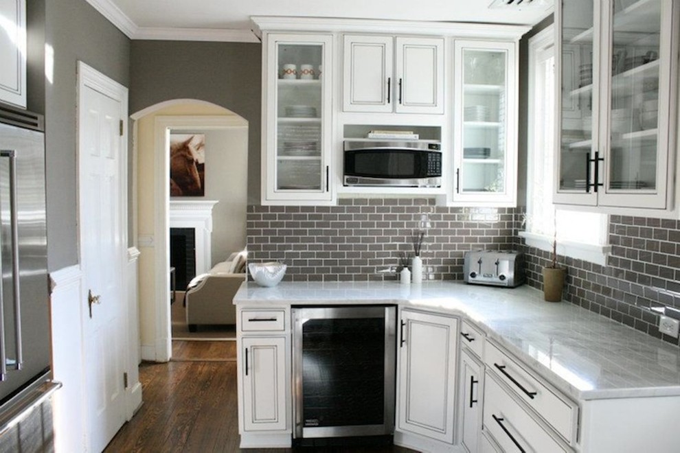Enclosed kitchen - small transitional l-shaped dark wood floor enclosed kitchen idea with beaded inset cabinets, white cabinets, quartz countertops, gray backsplash, subway tile backsplash, stainless steel appliances and no island