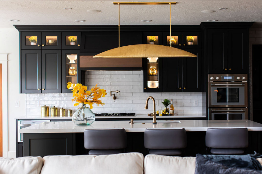 Inspiration for a large transitional medium tone wood floor kitchen remodel in Seattle with an undermount sink, quartz countertops, white backsplash, subway tile backsplash, stainless steel appliances, an island and white countertops