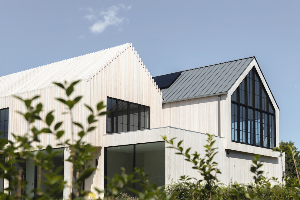 Источник вдохновения для домашнего уюта: деревянный, бежевый частный загородный дом в стиле модернизм с двускатной крышей, металлической крышей и черной крышей