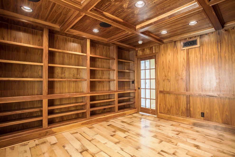 This is an example of a mid-sized traditional home office in Detroit with a library, brown walls, light hardwood floors, no fireplace and a built-in desk.