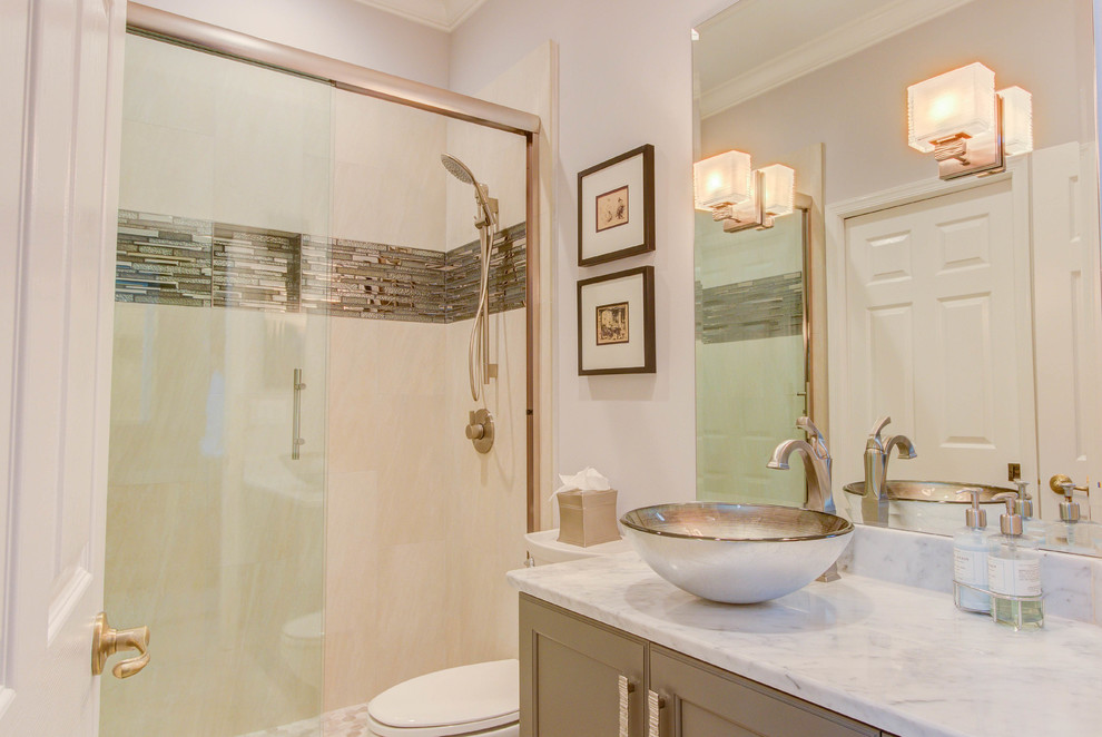 Small transitional 3/4 beige tile and porcelain tile ceramic tile alcove shower photo in Miami with flat-panel cabinets, gray cabinets, a two-piece toilet, beige walls, a vessel sink and marble countertops