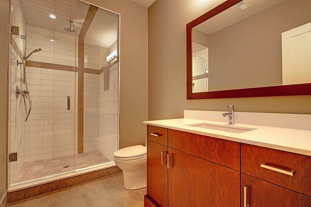 Photo of a mid-sized transitional 3/4 bathroom in Toronto with flat-panel cabinets, medium wood cabinets, an alcove shower, a one-piece toilet, grey walls, travertine floors and an undermount sink.