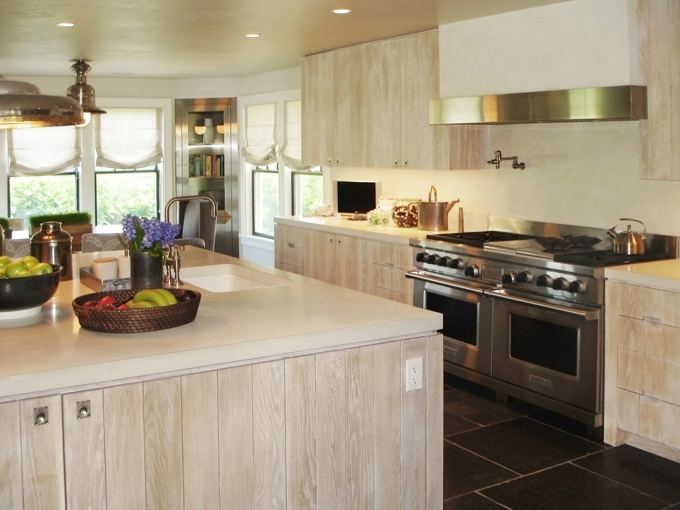 This is an example of a large transitional u-shaped separate kitchen in New York with an undermount sink, flat-panel cabinets, light wood cabinets, beige splashback, stainless steel appliances, with island and solid surface benchtops.