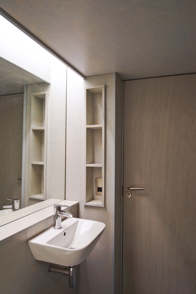 This is an example of a small scandi ensuite bathroom in London with flat-panel cabinets, blue cabinets, a built-in shower, a wall mounted toilet, blue tiles, blue walls, a wall-mounted sink, wooden worktops, blue floors, blue worktops, a single sink, a built in vanity unit, a drop ceiling and panelled walls.