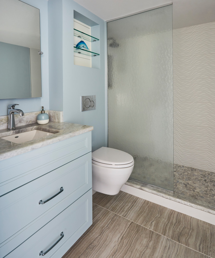 Design ideas for a small beach style 3/4 bathroom with shaker cabinets, blue cabinets, an alcove shower, a wall-mount toilet, blue tile, blue walls, porcelain floors, an undermount sink, marble benchtops, brown floor, an open shower, blue benchtops, a niche, a single vanity and a built-in vanity.
