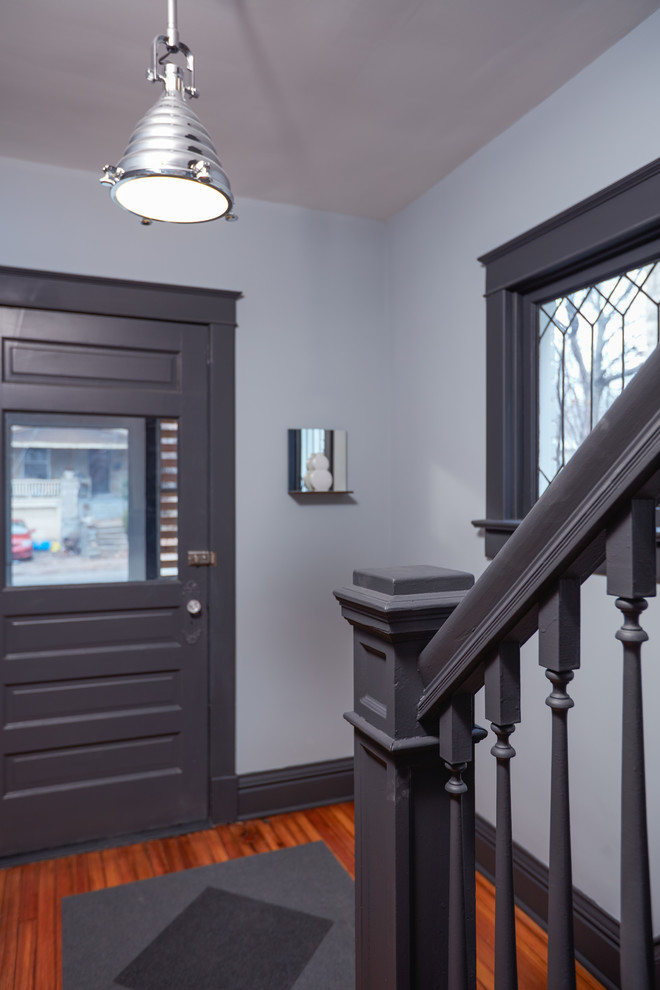 This is an example of a small contemporary front door in Kansas City with grey walls, a single front door, a gray front door, bamboo floors and brown floor.