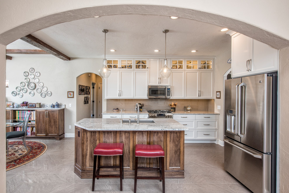Mid-sized elegant l-shaped gray floor eat-in kitchen photo with shaker cabinets, white cabinets, an island, an undermount sink, gray backsplash and stainless steel appliances