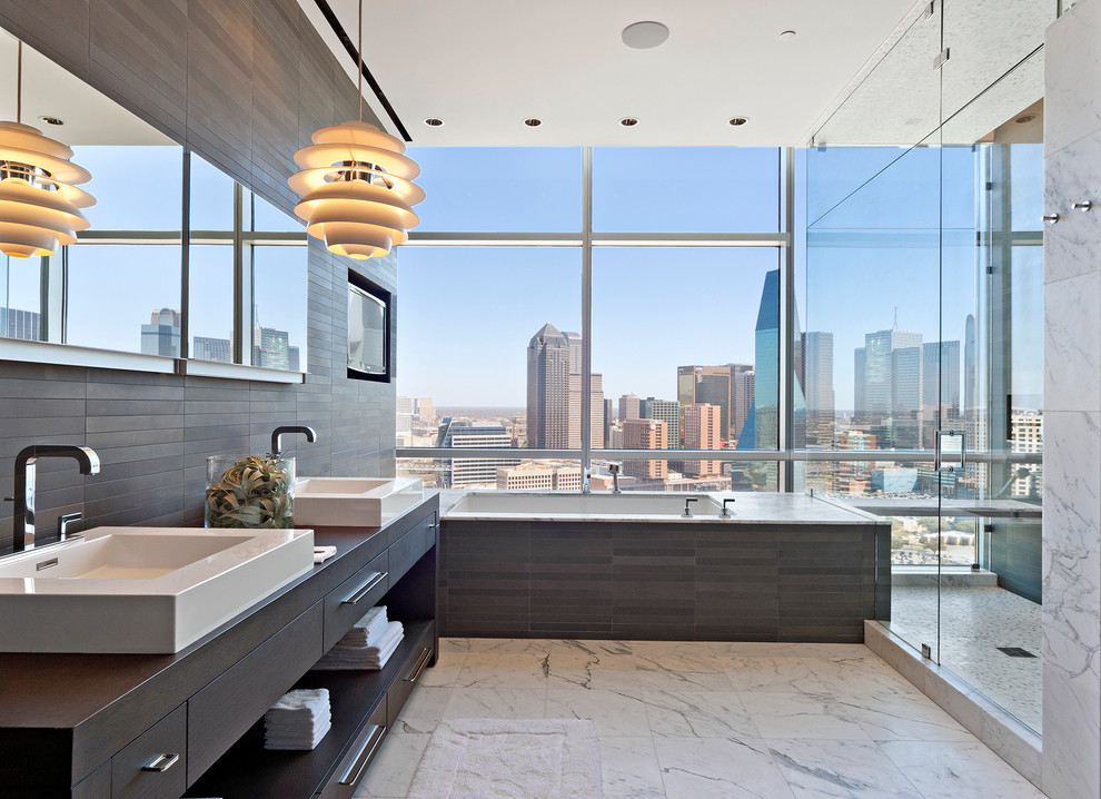 Photo of a modern bathroom in Dallas with a vessel sink, open cabinets, dark wood cabinets, an undermount tub, a corner shower and gray tile.