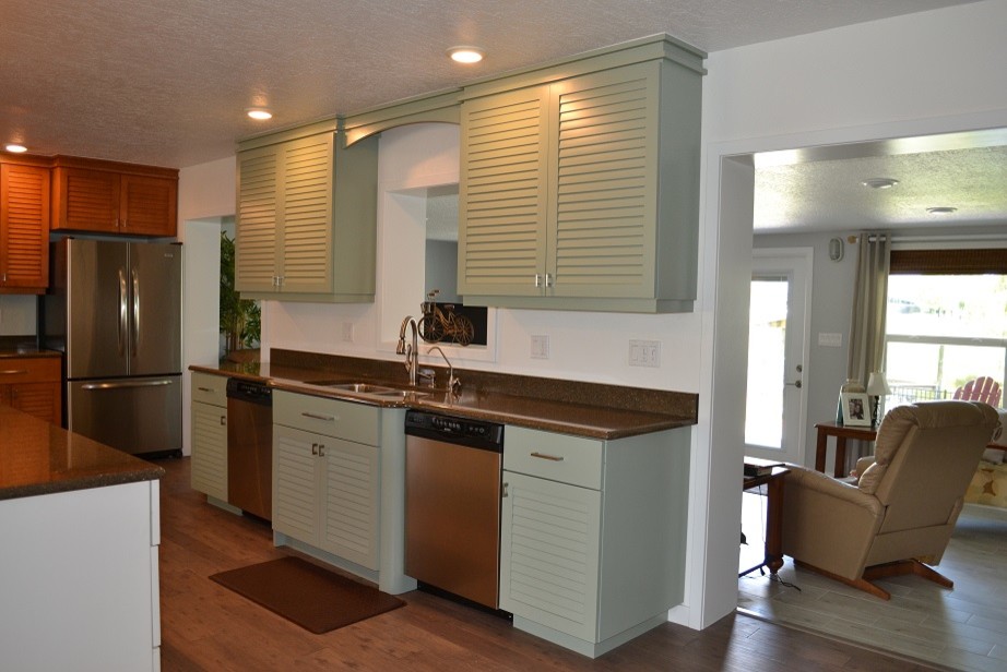 Photo of a mid-sized beach style l-shaped eat-in kitchen in Orlando with a double-bowl sink, louvered cabinets, green cabinets, stainless steel appliances and with island.