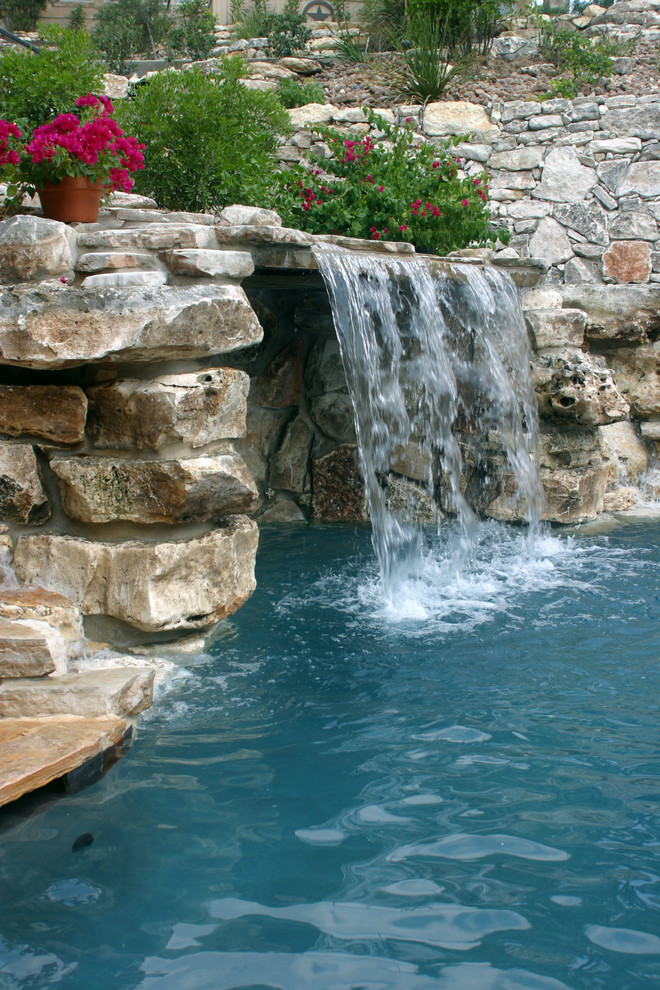 Large beach style backyard stone and custom-shaped hot tub photo in Austin