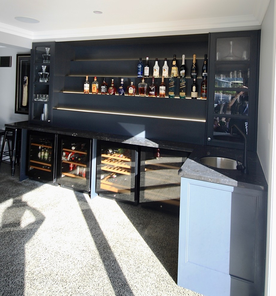 Photo of a mid-sized modern l-shaped wet bar in Sydney with recessed-panel cabinets, white cabinets, quartz benchtops, an undermount sink, blue splashback, concrete floors and grey floor.