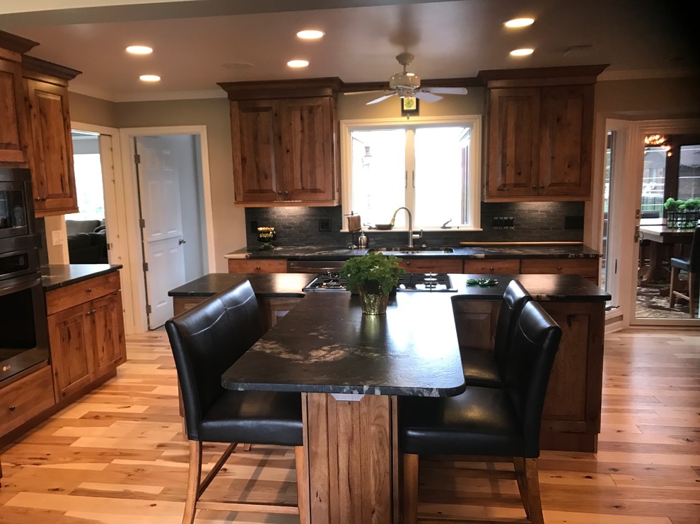 Eat-in kitchen - mid-sized rustic l-shaped eat-in kitchen idea with an undermount sink, raised-panel cabinets, medium tone wood cabinets, granite countertops and an island