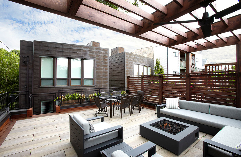 This is an example of a mid-sized transitional rooftop deck in Chicago with a fire feature and a pergola.