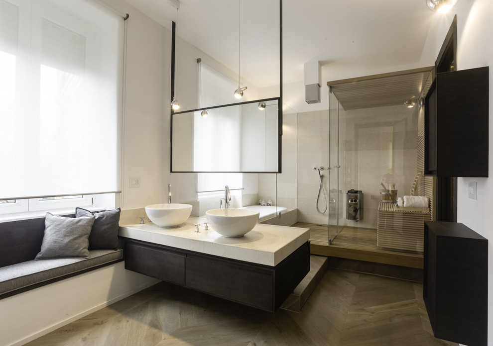 Inspiration for a large contemporary bathroom in Milan with flat-panel cabinets, dark wood cabinets, an alcove tub, an open shower, white walls, medium hardwood floors, with a sauna, a vessel sink, marble benchtops and beige floor.