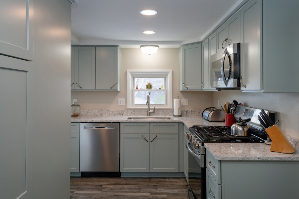 Inspiration for a small transitional l-shaped separate kitchen in Other with an undermount sink, shaker cabinets, green cabinets, quartz benchtops, stainless steel appliances, vinyl floors, a peninsula, brown floor and grey benchtop.
