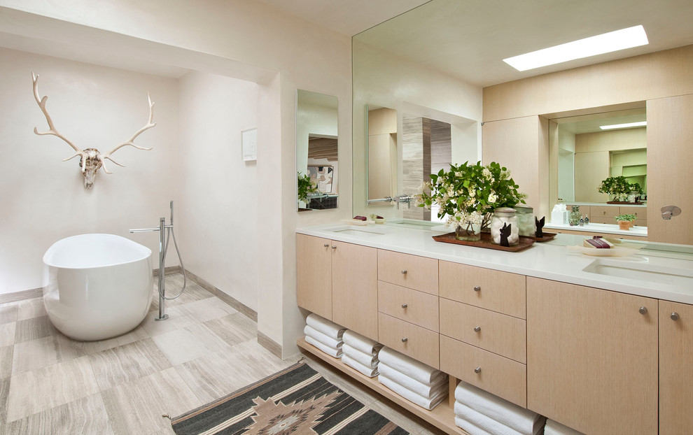 Mid-sized mediterranean master bathroom in Albuquerque with open cabinets, light wood cabinets, a freestanding tub, beige tile, beige walls, slate floors, engineered quartz benchtops and white benchtops.