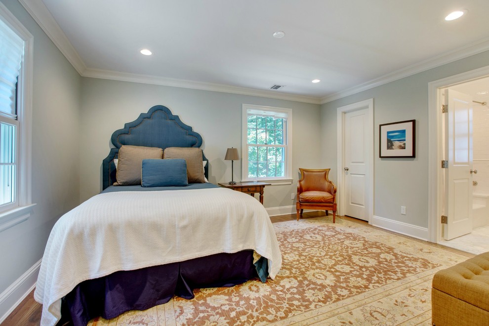 Large transitional master bedroom in New York with grey walls, light hardwood floors and no fireplace.