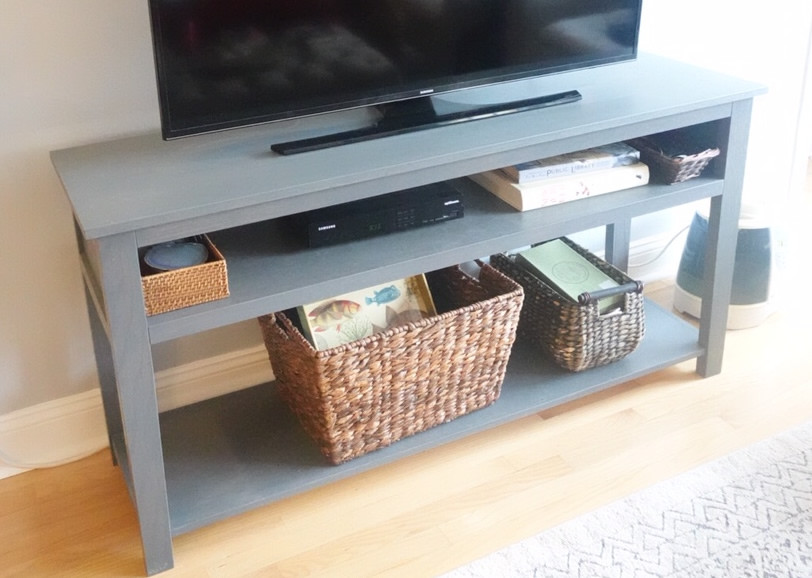 Modelo de salón abierto actual de tamaño medio con paredes grises, suelo de madera clara y televisor independiente
