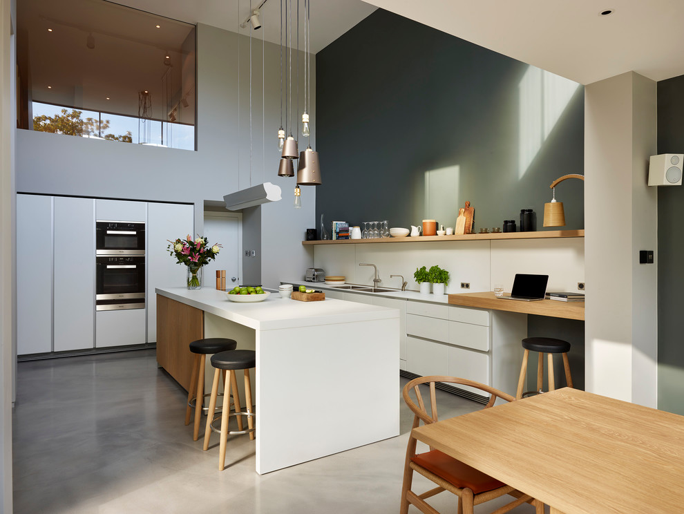 Inspiration for a contemporary eat-in kitchen in London with a double-bowl sink, open cabinets, white splashback, concrete floors and with island.