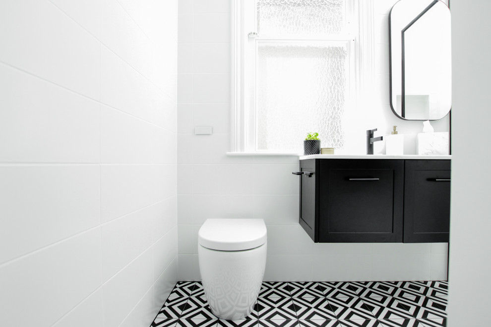 Inredning av ett modernt litet badrum, med skåp i shakerstil, svarta skåp, en öppen dusch, en toalettstol med hel cisternkåpa, vit kakel, ett undermonterad handfat och med dusch som är öppen